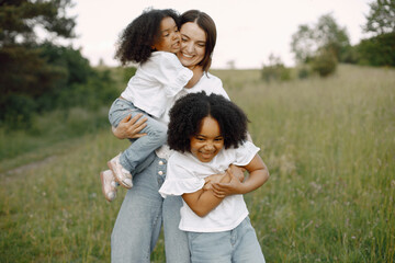 Fototapeta premium Caucasian mother embracing her mixed race daughters