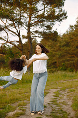 Caucasian mother twirling her mixed race daughter