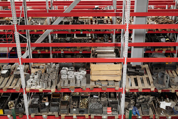 Part of spacious distribution warehouse of industrial plant with shelves full of spare parts for...