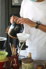 Coffee shop worker standing at the counter with hand drip coffee set