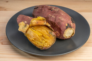 Baked sweet potato closeup, Japanese Roasted Sweet Potato on black plate.