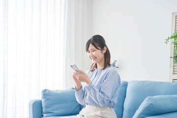 女性　スマホ　リビング