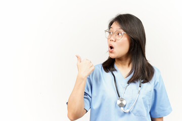 Showing and Pointing Product With Thumb Of Asian Young Doctor Isolated On White Background