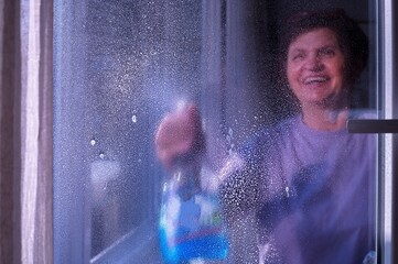 Portrait of senior woman  cleaning windows