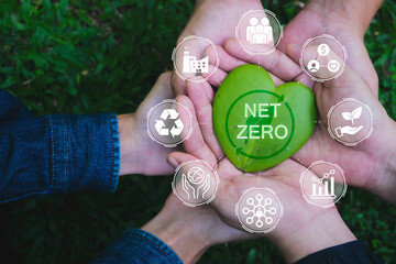 Net zero and carbon neutral concept. Hands adult Teamwork harmony Holding heart leaf on hands with...