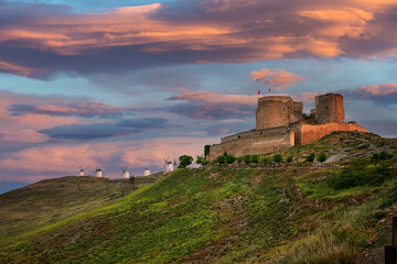 Fototapeta premium Spanish castle and windmills in the warm evening light