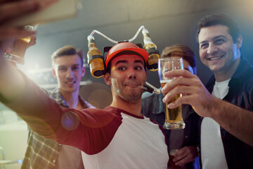 Snapping some party pics. Cropped shot of guys taking a selfie while drinking beer at a party.