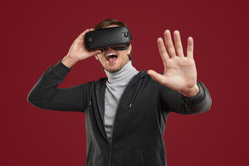 Shocked man experiencing virtual reality in VR goggles