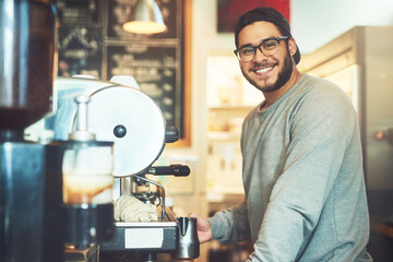 Hes a master when it comes to coffee. Portrait of a young barista working in a cafe.
