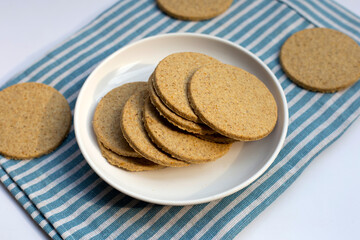 Oatcakes in white plate on white background.