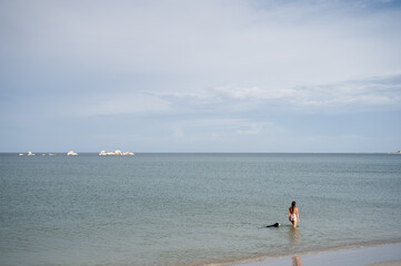 Women and dog take a dip in the ocean
