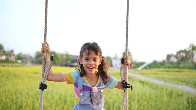 Girls are playing on the swing with fun and cheerfulness, playing to develop the body and brain to suit childhood