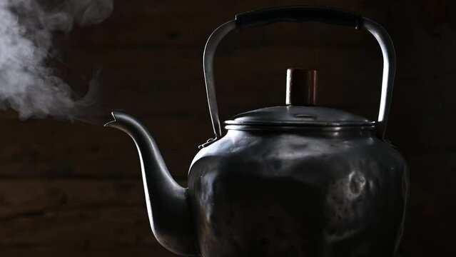 silhouette footage of water boiling in kettle on fire