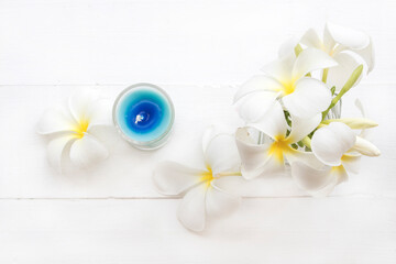 white flowers frangipani local flora of asia with candle arrangement flat lay postcard style on background white wooden