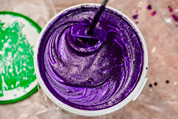 Purple wall paint. Stirring in a bucket of paint for repairs.