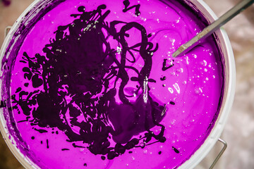 Purple wall paint. Stirring in a bucket of paint for repairs.