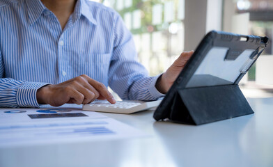 Businessman office worker sitting at a desk looking at tablet discussing working analyzing with financial data and marketing growth report graph