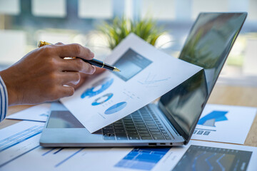 Businessman sitting at a desk financial data analysis and market growth report graph and investment results, analytical concepts and financial investments.