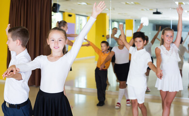 Fototapeta na wymiar Active positive children enjoying of partner dance in class