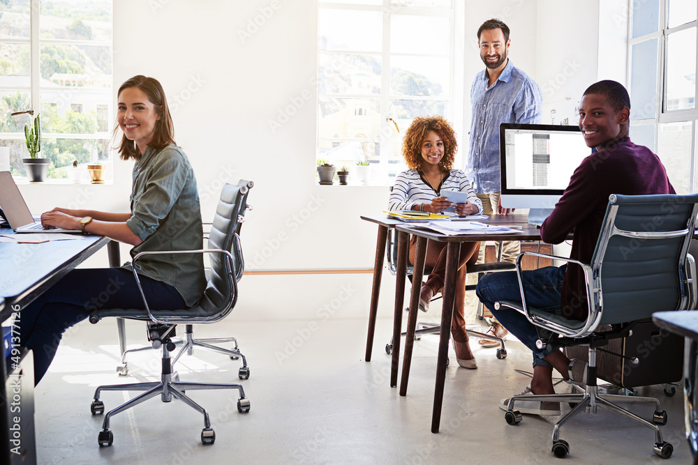Poster Our office layout improves productivity. Portrait of a team of colleagues working in an open plan office.