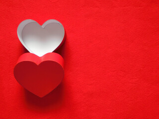 赤いフェルトの左側に置いたハート形の箱と蓋