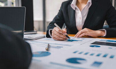 Business people discussing the charts and graphs showing the results of their successful teamwork with laptops planning strategy and brainstorming, colleagues thinking concept