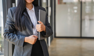 Naklejka premium woman in business clothes holding laptop computer