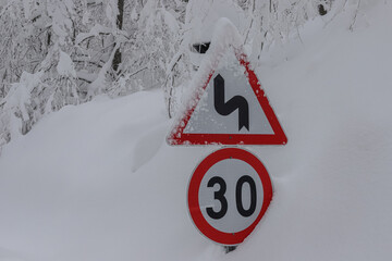 a snow-covered road sign and the beautiful view behind it