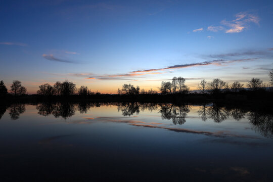Beautiful sunset over a little lake with a perfect reflection image near Thierhaupten, Meitingen, Bavaria, Germany, 