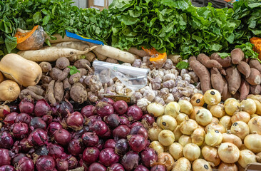 Different kinds of onions and potatoes far sale at a market