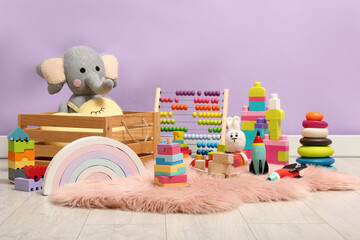 Set of different toys on rug near violet wall