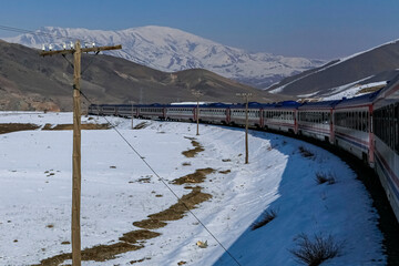 a train moving on the road with snow and mountain views