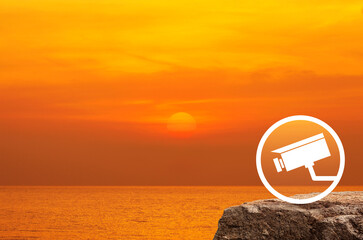cctv camera flat icon on rock mountain over sunset sky and sea, Technology security concept