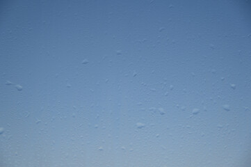 water drops on the window against the blue sky, rain on the glass