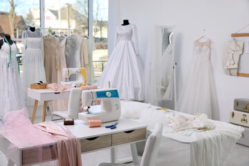 Dressmaking workshop interior with wedding dresses and equipment