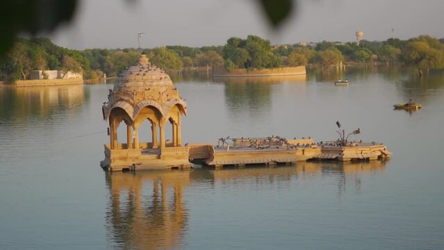 View of the Chhatri in the middle of the Gadisar Lake at Jaisalmer in Rajasthan, India. Reflection of the Chhatri pavilion in the water of the lake.
