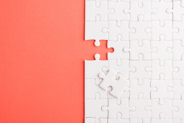 Top view flat lay of paper plain white jigsaw puzzle game texture last pieces for solve and place, studio shot on a red background, quiz calculation concept