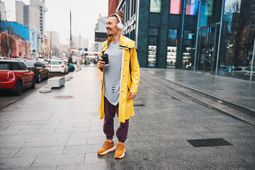 Smiling handsome guy drinking coffee in city centre