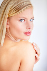 Naklejka premium My skin has never felt more beautiful. Beautiful young woman touching her skin against a white background.