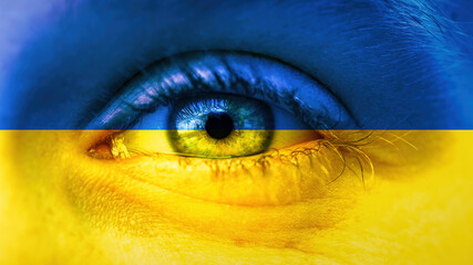 War in Ukraine background - Close-up of child's eyes with tears, in the colors of Ukrainian flag