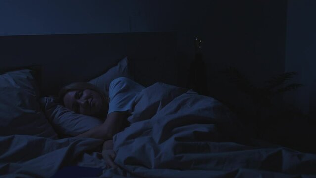 The woman sleeps in her bed. Restful sleep is essential for recuperation.