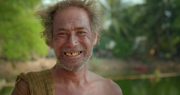 Happy smiling male Asian farmer and mercenary man with beard who is a poor indigenous man would catch fish with nets to feed his livelihood in natural pools.
