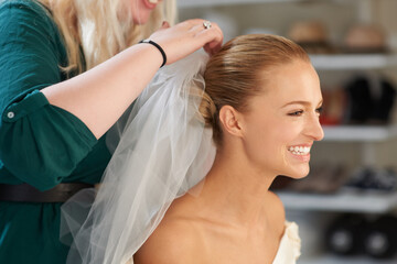 Naklejka premium Placing those finishing touches. A young bride getting her hair done before the wedding.