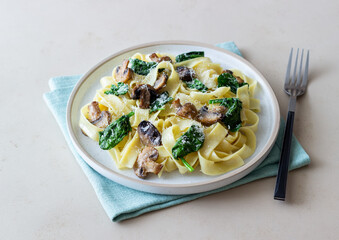 Linguini pasta with mushrooms, spinach and cheese. Healthy eating. Vegetarian food. Italian cuisine.
