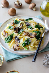 Linguini pasta with mushrooms, spinach and cheese. Healthy eating. Vegetarian food. Italian cuisine.