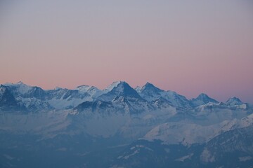 Pink sky over Eiger, Monch and Jungfrau. Sunrise scene in the Swiss Alps.