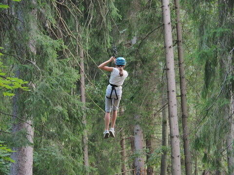 woman goes zipline high above the water