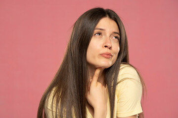 Fototapeta premium Portrait of young attractive beautiful thoughtful woman thinking look copyspace isolated on pink background