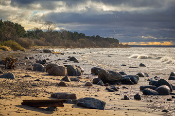 dark clouds on a windy beach with stone shore coast
