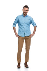 handsome unshaved guy with chino pants and sneakers smiling